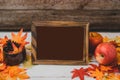 Autumn and Fall season. Empty photo frame and fake maple leaf on wood table. Harvest cornucopia and Thanksgiving day