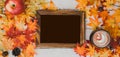 Autumn and Fall season. Hot chocolate with photo frame and fake maple leaf on wood table. Harvest cornucopia and Thanksgiving