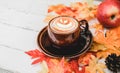 Autumn and Fall season. Hot coffee with fake maple leaf on wood table. Harvest cornucopia and Thanksgiving day