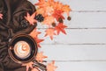 Autumn and Fall season. Hot coffee with fake maple leaf on wood table. Harvest cornucopia and Thanksgiving day