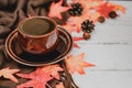 Autumn and Fall season. Hot coffee with fake maple leaf on wood table. Harvest cornucopia and Thanksgiving day