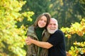 Autumn family. Loving grandfather hugging of adult granddaughter, hoary elderly father cuddle grown up daughter showing Royalty Free Stock Photo