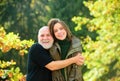 Autumn family. Loving grandfather hugging of adult granddaughter, hoary elderly father cuddle grown up daughter showing