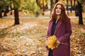 Autumn fashion, earth tones style, bright fall color palette. Portrait of red-haired girl in purple coat Royalty Free Stock Photo