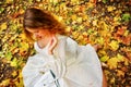 Autumn fashion dress woman sitting fall leaves city park outdoor. Royalty Free Stock Photo