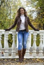 Autumn fashion image of young woman walking in the park