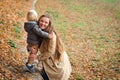 Autumn fashion, lifestyle. Young family having fun together in autumn park. Happy mother and child playing and laughing on autumn Royalty Free Stock Photo