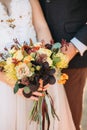 Autumn fashion wedding bouquet in hands of the bride and groom. Royalty Free Stock Photo