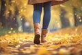 Autumn fashion woman in jeans and boots walking in park Royalty Free Stock Photo