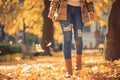 Autumn fashion woman in jeans and boots walking in park Royalty Free Stock Photo