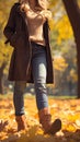 Autumn fashion woman in jeans and boots walking in park Royalty Free Stock Photo
