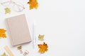 Autumn feminine desk table with paper notebook, glasses, maple leaves on white background. Blogger workspace top view Royalty Free Stock Photo