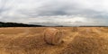 Autumn field with sheaves of hay and dramatic sky. Royalty Free Stock Photo