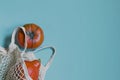 Autumn flat composition with orange pumpkins in a mesh shopping bag on a gentle blue background. Creative Autumn, Thanksgiving Day