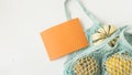 Autumn flat lay composition with orange pumpkins in mesh shopping bag on white background. Creative autumn, thanksgiving, fall,