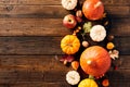 Autumn flat lay composition with pumpkins, fall leaves, apple, red berries on dark wooden table. Top view. Autumn, Fall, Halloween