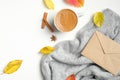 Autumn flat lay composition. Romantic breakfast with morning coffee cup, cinnamon sticks, fallen leaves, female knitted sweater on