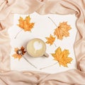 Autumn flat lay with cup coffee cappuccino with art heart and yellow autumnal leaves Royalty Free Stock Photo