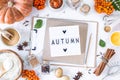 Autumn flat lay with lightbox with the phrase Autumn. Top view. Food ingredients for making autumn pumpkin pie on a white stone Royalty Free Stock Photo