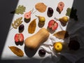 Autumn flat lay with pumpkin apples pears plums and fall leaves with linen table cloth on white background harsh shadows