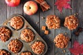 Autumn flat lay scene with warm apple caramel muffins over rustic wood