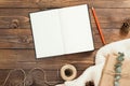 Autumn flatlay composition. Top view on book with empty pages, red pen, rope, gift box on wooden background. Autumn hygge style Royalty Free Stock Photo