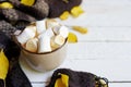 Autumn flatlay with cup of coffee, scarf, yellow leaves on white wooden background with copy space