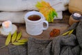 autumn flatlay in style Scandinavian hugg with tea in mugwarm woolen clothes, yellow leaves on wooden table, candle is burning, Royalty Free Stock Photo