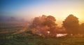 Autumn foggy river sunrise. Colorful misty morning dawn. Fall rural scene panorama