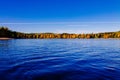 Autumn foliage, fall colorful forest over blue lake with red cabins in Finland Royalty Free Stock Photo