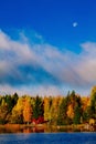 Autumn foliage, fall colorful forest over blue lake with red cabins in Finland Royalty Free Stock Photo