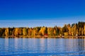 Autumn foliage, fall colorful forest over blue lake with red cabins in Finland Royalty Free Stock Photo