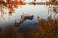 Autumn foliage and fog lake in morning with boat dock. Royalty Free Stock Photo