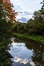 Autumn foliage is reflected in the river. Riverside environmnet of autumn river Royalty Free Stock Photo