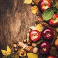 Autumn food background. Ripe apples with nuts, fallen leaves and cinnamon on rustic wooden table. Top view. Copy space Royalty Free Stock Photo