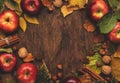 Autumn food background. Ripe apples with nuts, fallen leaves and cinnamon on rustic wooden table. Top view. Copy space Royalty Free Stock Photo