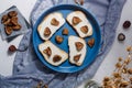 Autumn food composition, cream cheese sandwiches with dried figs. No sugar healthy diet. Blue fabric and dry flowers on white