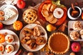 Autumn food table scene with pies, appetizers and desserts. Top view over a rustic wood background.