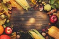 Autumn food top view, Thanksgiving or Halloween background: pumpkins, nuts, fallen leaves and spices on brown wooden background. Royalty Free Stock Photo