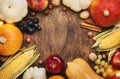 Autumn food top view, Thanksgiving or Halloween background: pumpkins, nuts, fallen leaves and spices on brown wooden background. Royalty Free Stock Photo