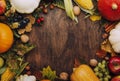 Autumn food top view, Thanksgiving or Halloween background: pumpkins, nuts, fallen leaves and spices on brown wooden background.