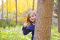 Autumn forest with child girl greeting hand in tree trunk