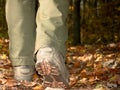 Woman in high leather shoes or boots walking on fallen leaves Royalty Free Stock Photo