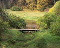 Autumn forest and wooden bridge across the river Royalty Free Stock Photo