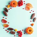 Autumn frame with leaves, rowan berries, orange pumpkins, pine cones on pastel background, flat lay. Fall, thanksgiving concept. Royalty Free Stock Photo