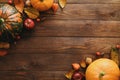 Autumn frame made of pumpkins, dried fall leaves, apples, red berries, walnuts, blanket on wooden table. Thanksgiving, Halloween,