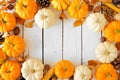 Autumn frame of pumpkins, leaves and natural fall decor on a white wood background