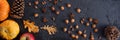 Autumn frame of pumpkins, tree leaves, hazelnuts on a black textural background. Autumn, fall, thanksgiving concept. Flat lay, ,