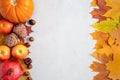 Autumn frame with yellow maple leaves, nuts, apples and pumpkin. Fall harvest on concrete gray background flat lay with copy space Royalty Free Stock Photo