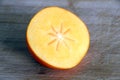Autumn fruits: half persimmon on a chopping board